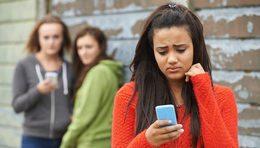 Image of 3 girls holding cell phone