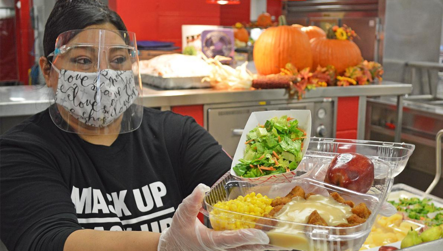 Cafeteria worker holding a plate of food