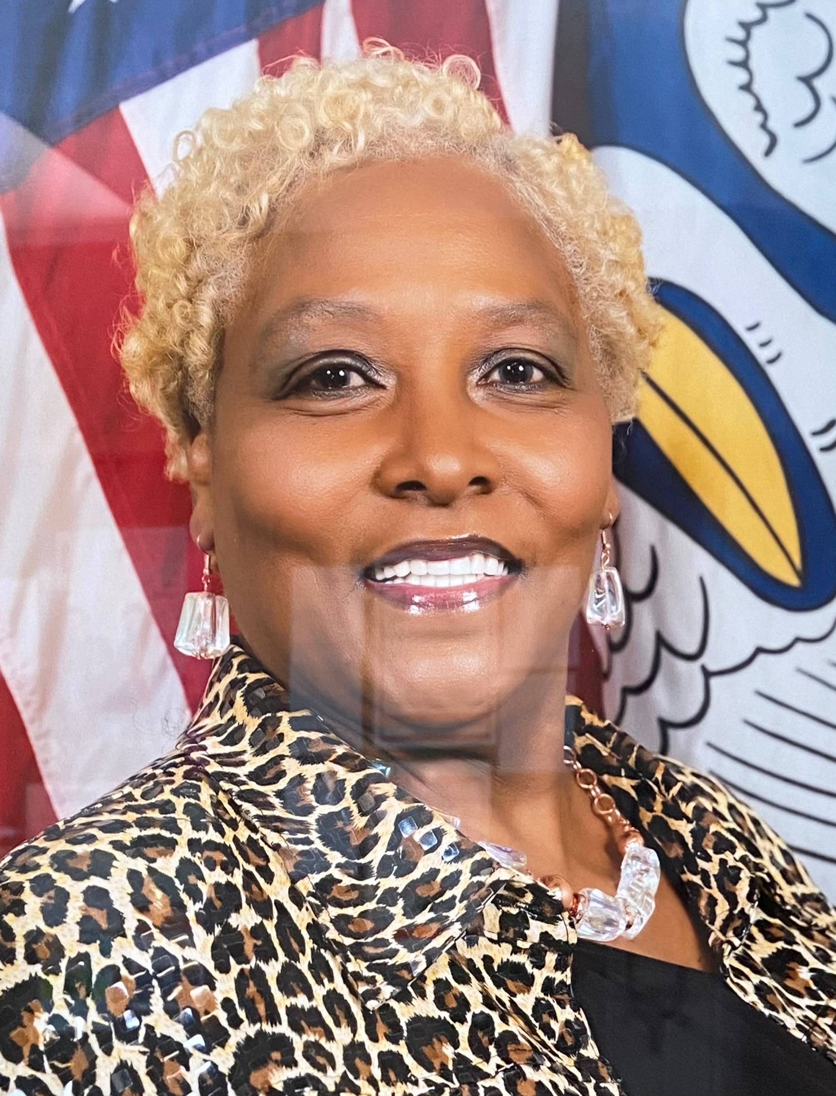 A woman with blonde hair holding an American flag.