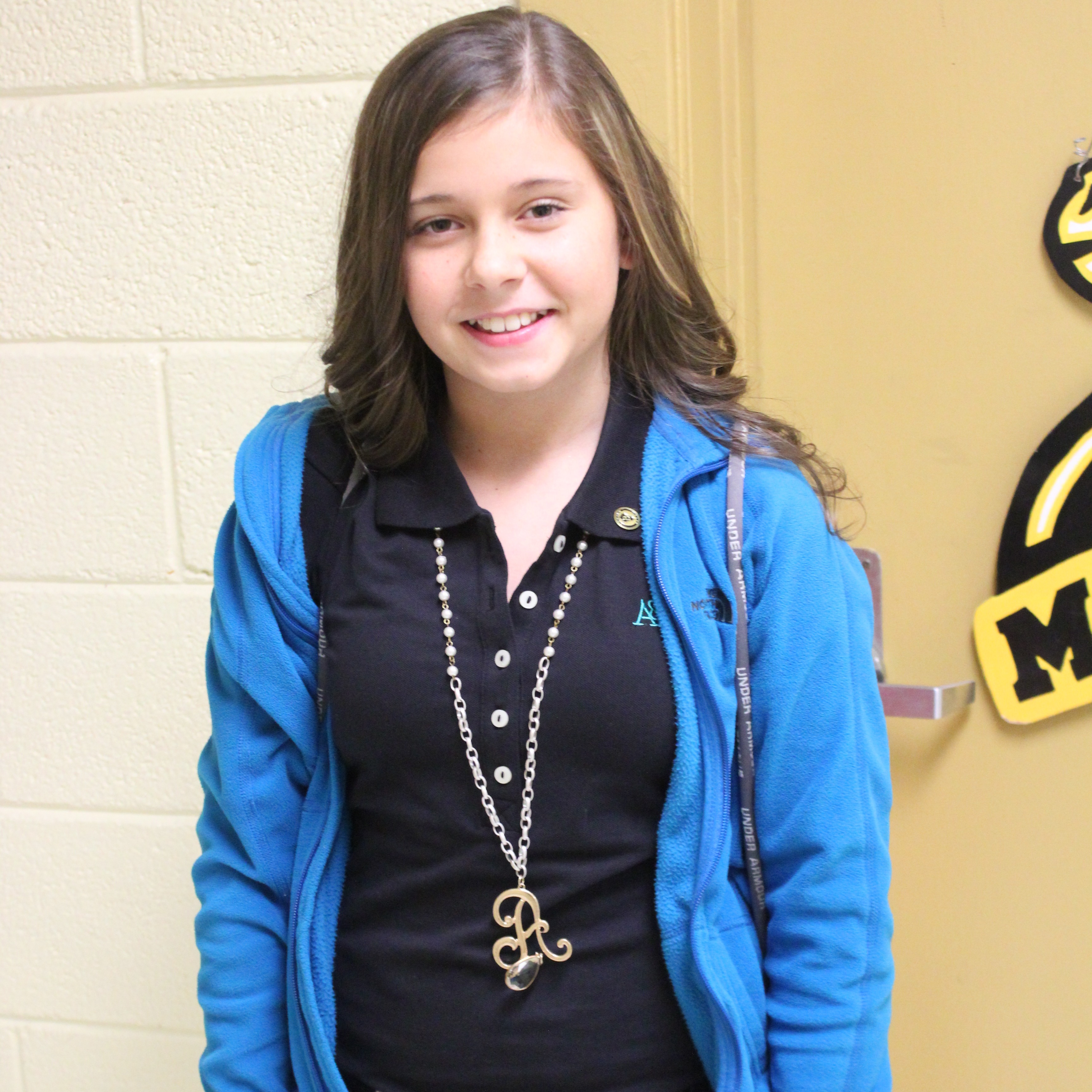 A girl wearing a blue jacket and black shirt.