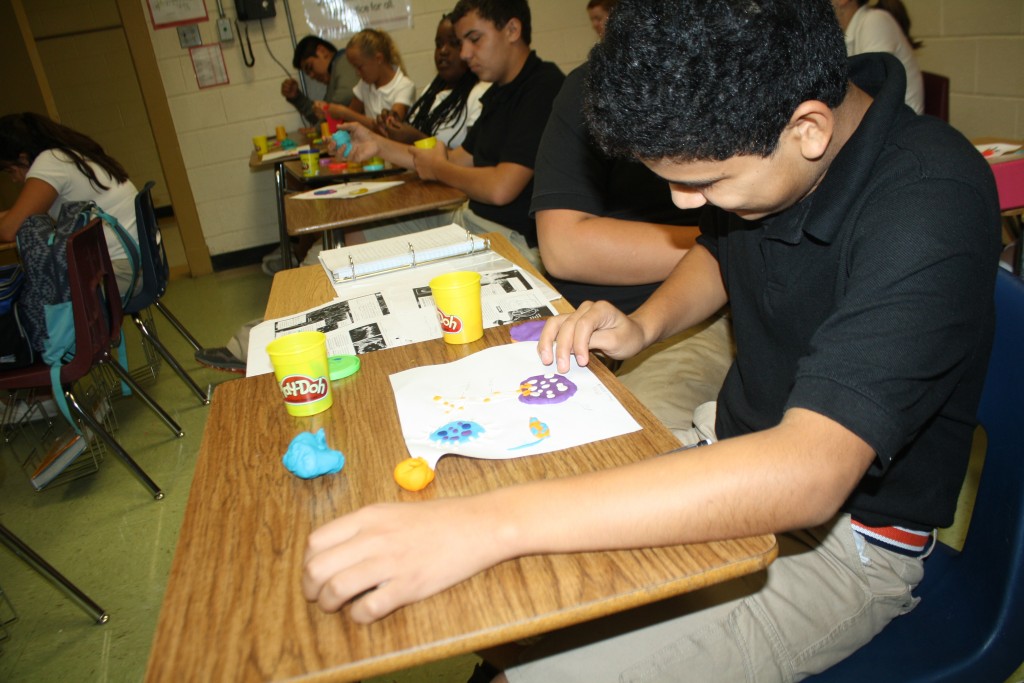 A boy creating a craft in a classroom.