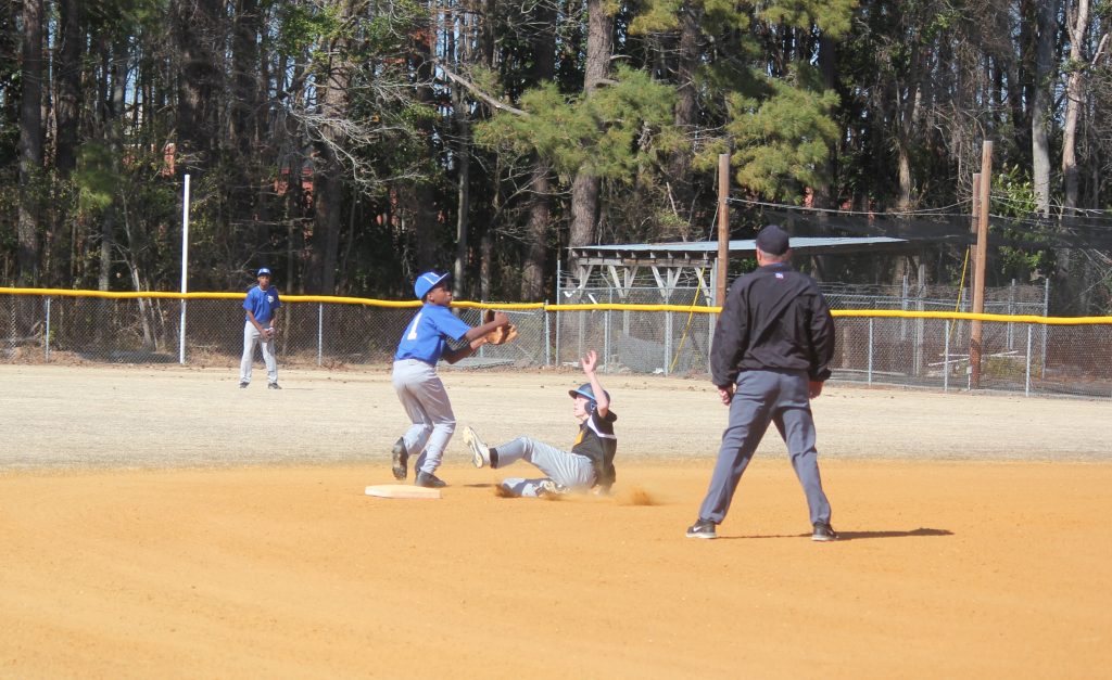 Baseball player sliding into home plate during a game.