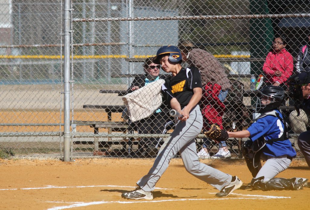 A baseball player swinging a bat at a ball during a game.