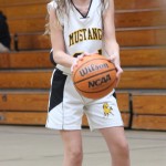 A girl is playing basketball on a court