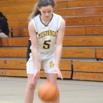 A girl is playing basketball on a court