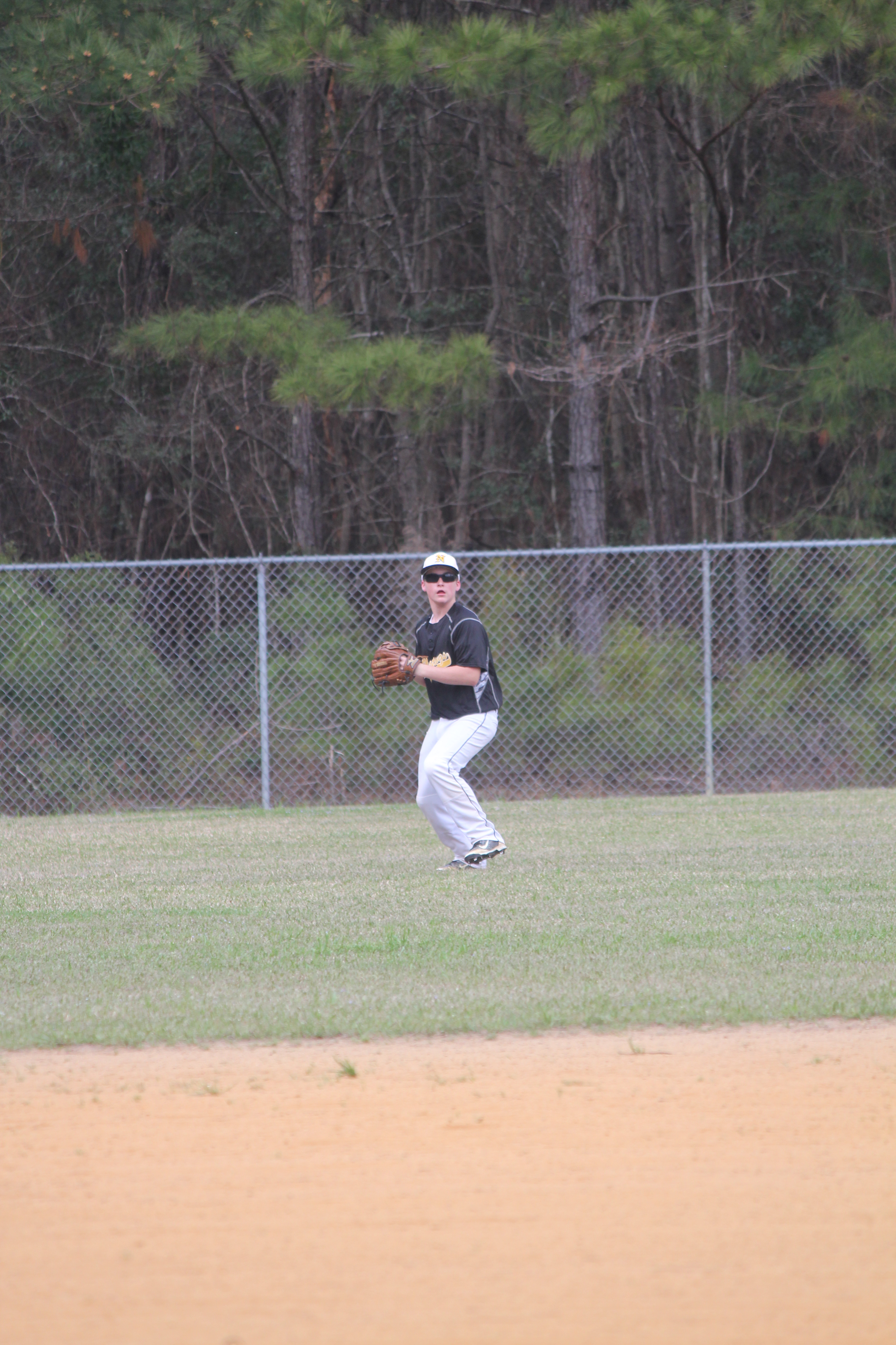 A baseball player catches a fly ball in the outfield during a game.