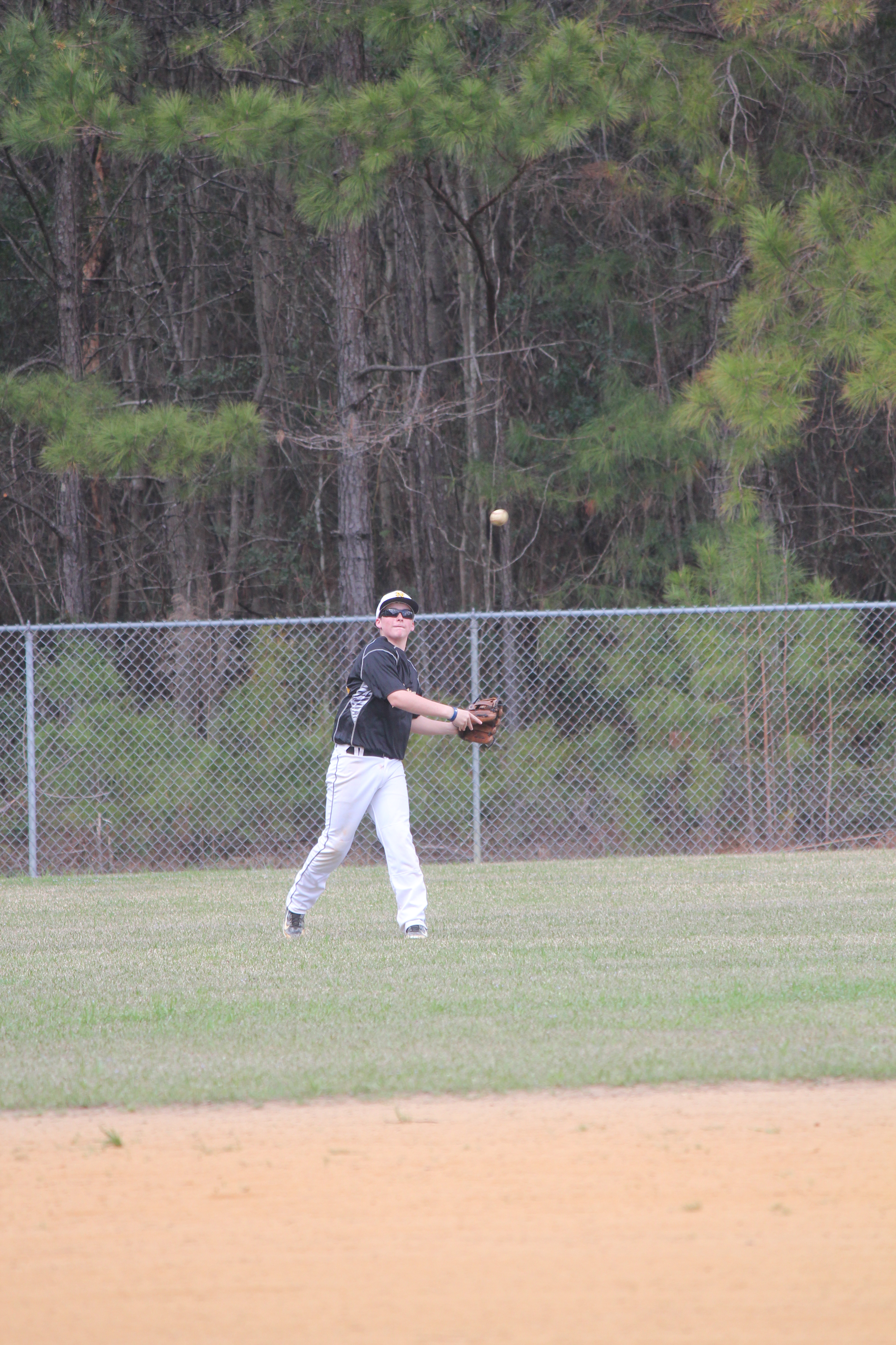 A baseball player throwing a  ball in the outfield during a game.