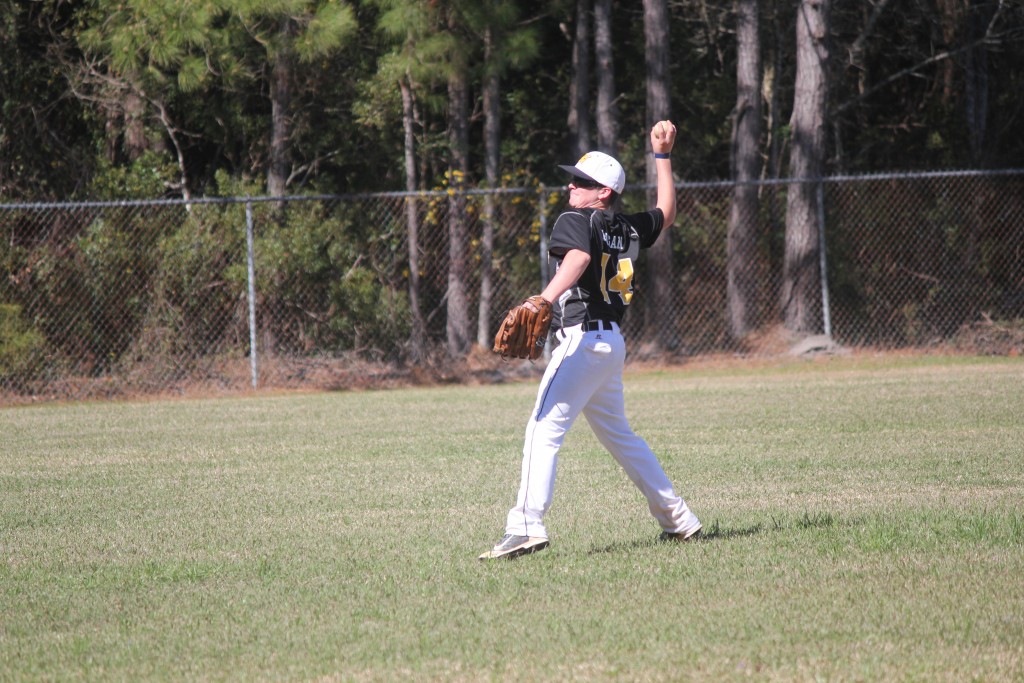 A baseball player mid-throw, releasing the ball into the air.