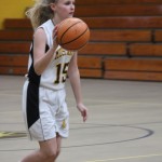 A girl is playing basketball on a court