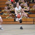 A girl is playing basketball on a court