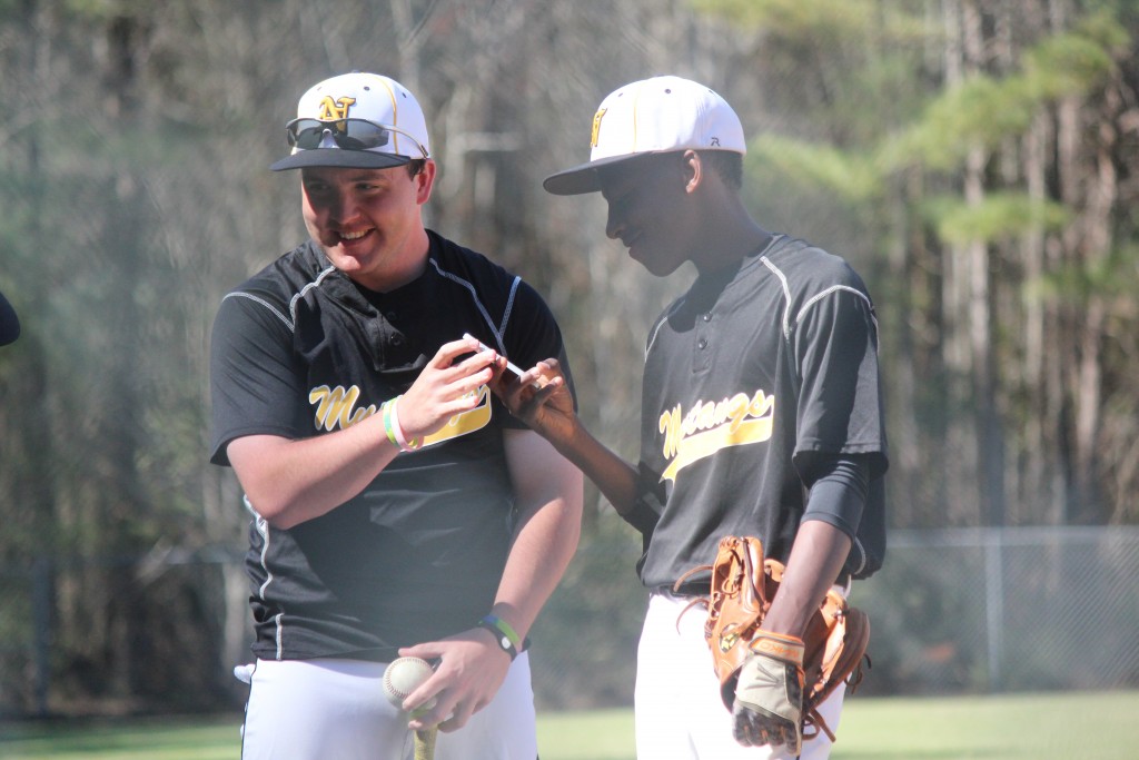 Two baseball players having a conversation on the field during a game.