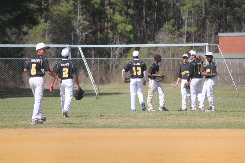 A team of baseball players in uniform standing on a green field, ready to play a game.