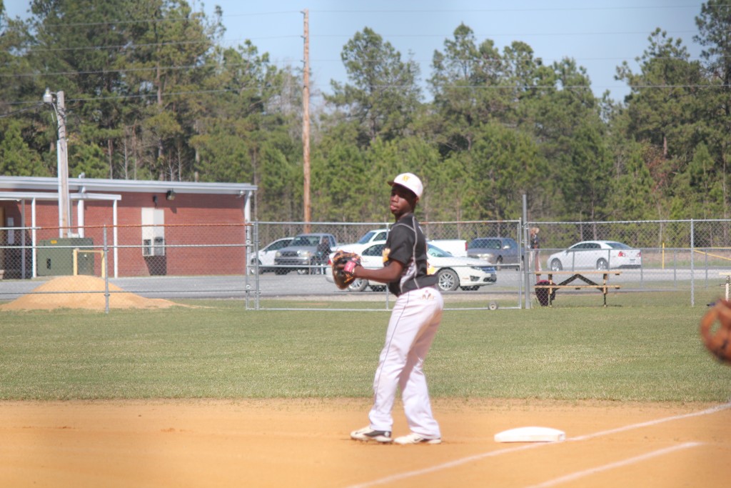 Baseball player in uniform standing on field with glove, ready to throw a ball during a game.