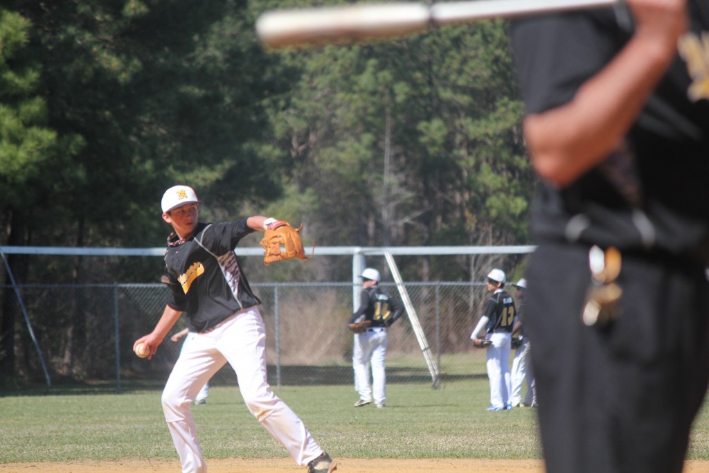 A baseball player in mid-throw during a game.