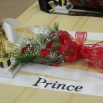 A bouquet of flowers on a table with a crown and a sign that says prince.