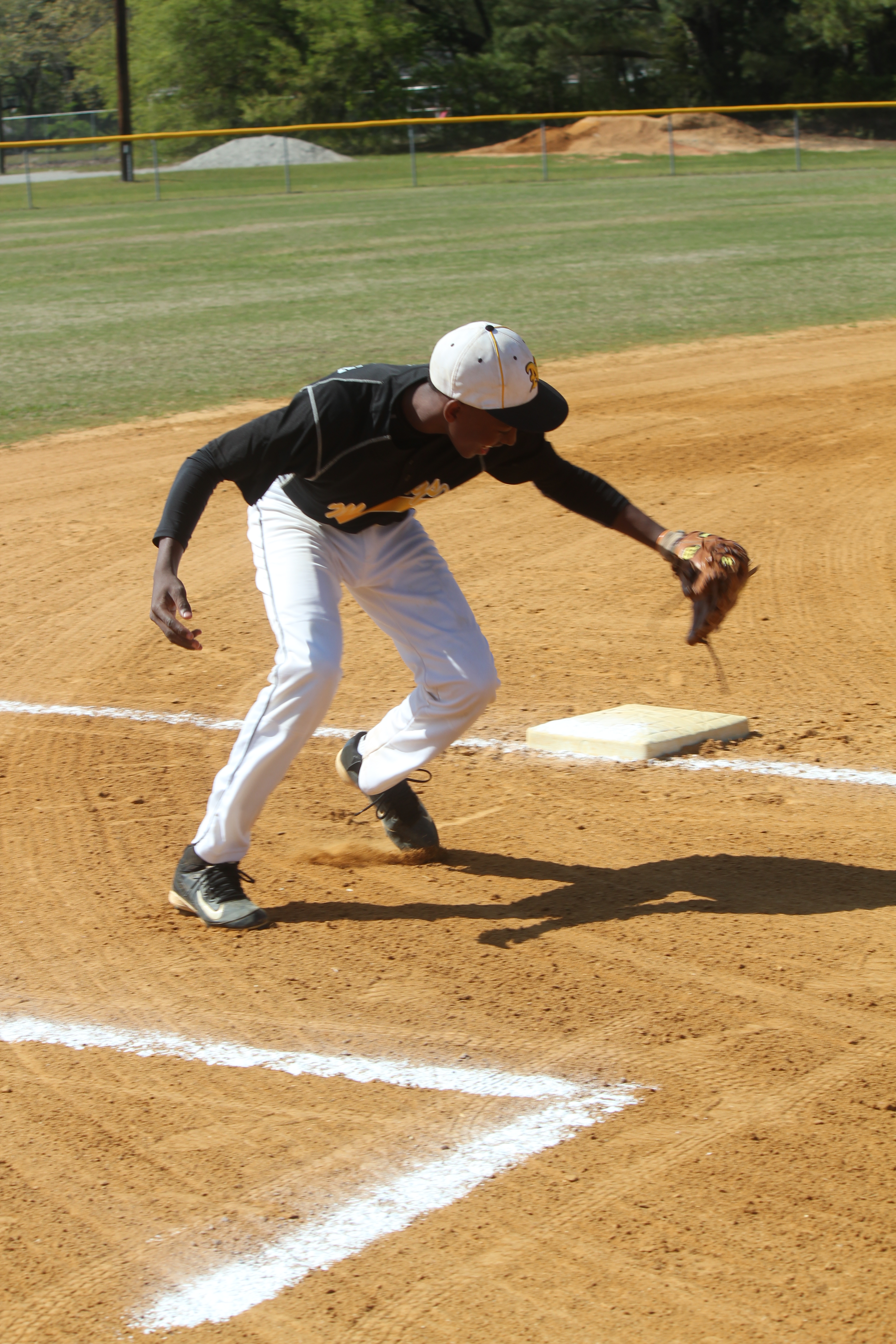 Baseball player sprinting to catch a fly ball in the outfield during a game.