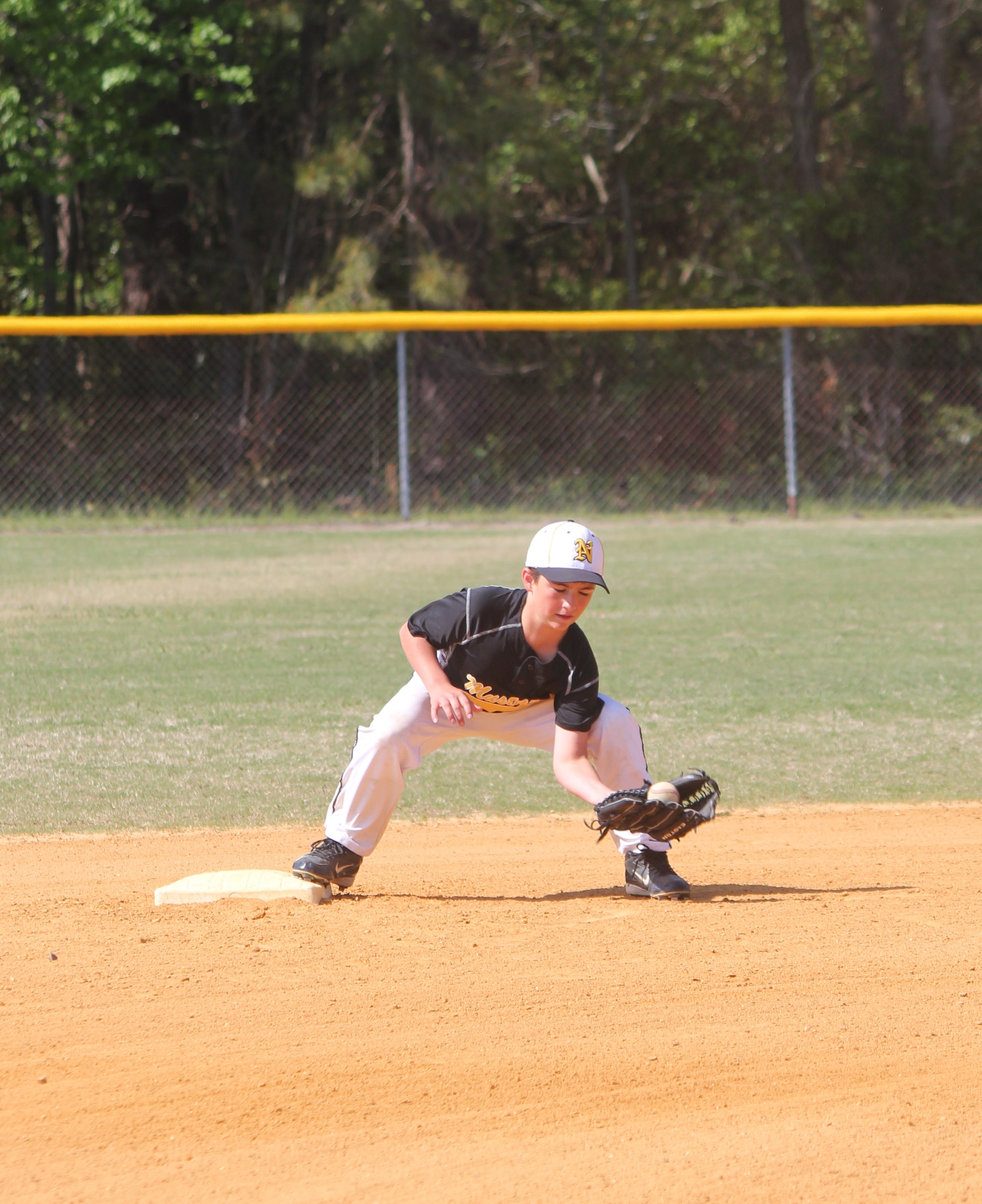 A baseball player sprinting to catch a fly ball in the outfield during a game.