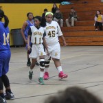 Girls basketball team playing energetically on the court, passing and scoring points.