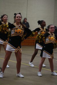 Cheerleaders performing energetic routine at a competition.