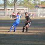 Image of soccer game with airborne ball.