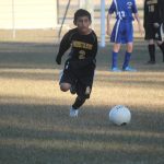 Image of soccer game with airborne ball.