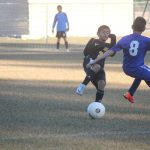 Image of soccer game with airborne ball.