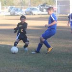 Image of soccer game with airborne ball.