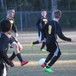 Image of soccer game with airborne ball.