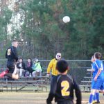 Image of soccer game with airborne ball.