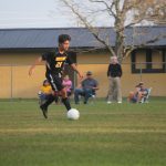 Image of soccer game with airborne ball.