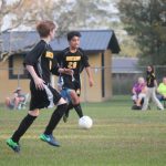 Image of soccer game with airborne ball.