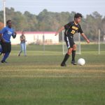 Image of soccer game with airborne ball.