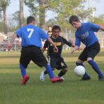 Image of soccer game with airborne ball.