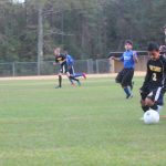 Image of soccer game with airborne ball.