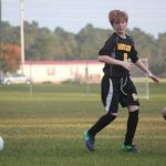 Image of soccer game with airborne ball.