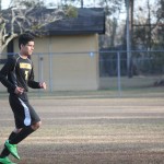 Young boy playing soccer on field.