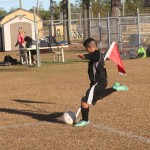 Young boy playing soccer on field.