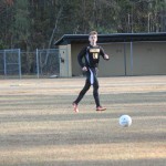 Young boy playing soccer on field.