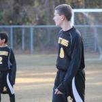 Young boys playing soccer on field.