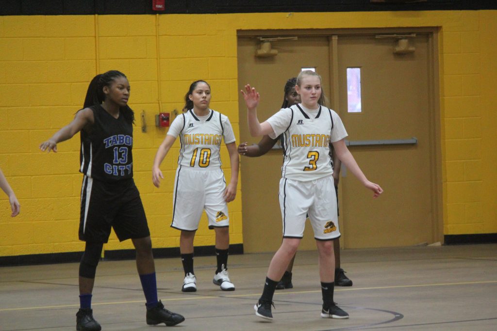 Girls' basketball team in motion, competing on the court with focus and determination.