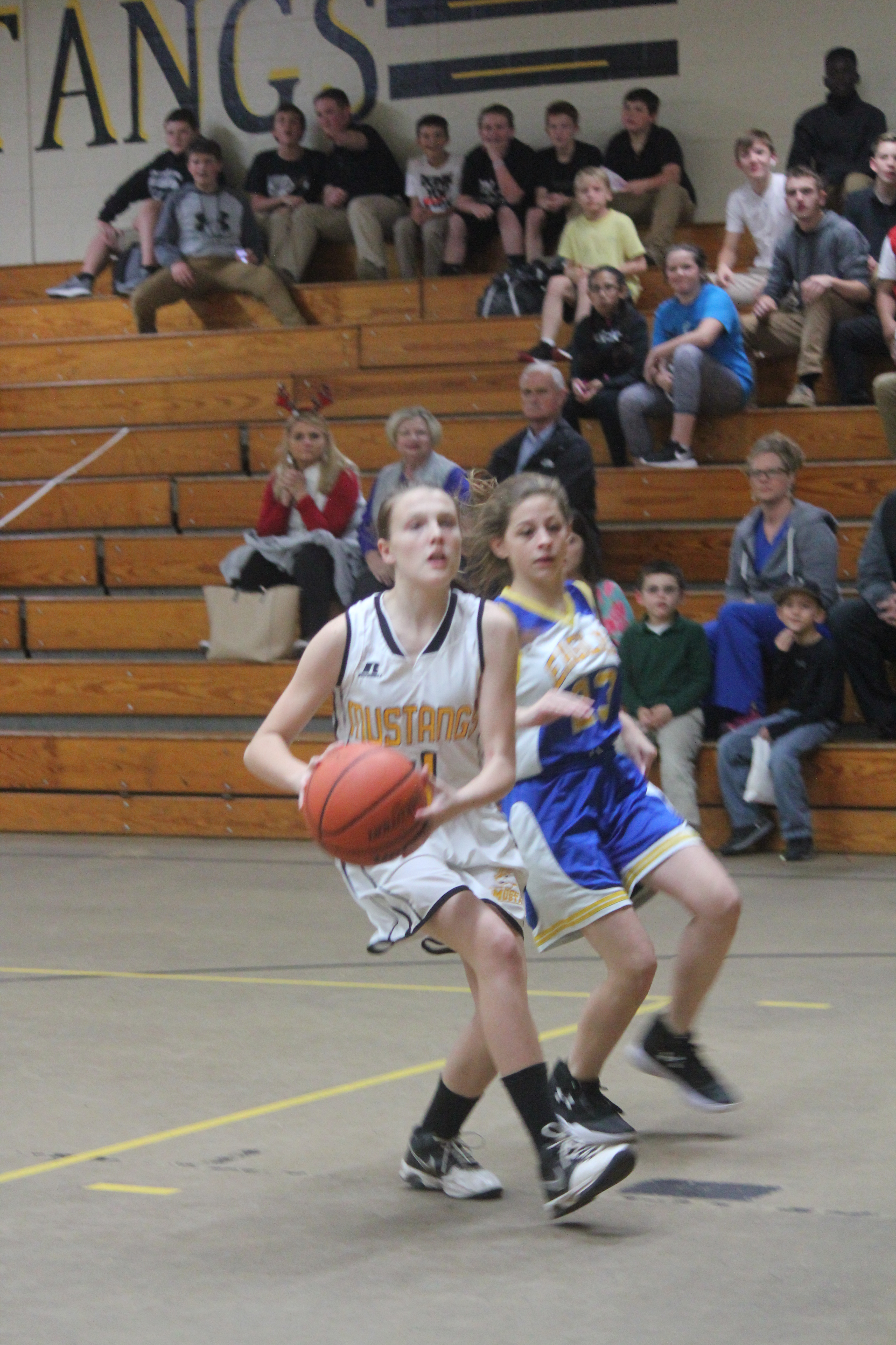 Young female athlete in white and yellow uniform trying to pass the ball. 