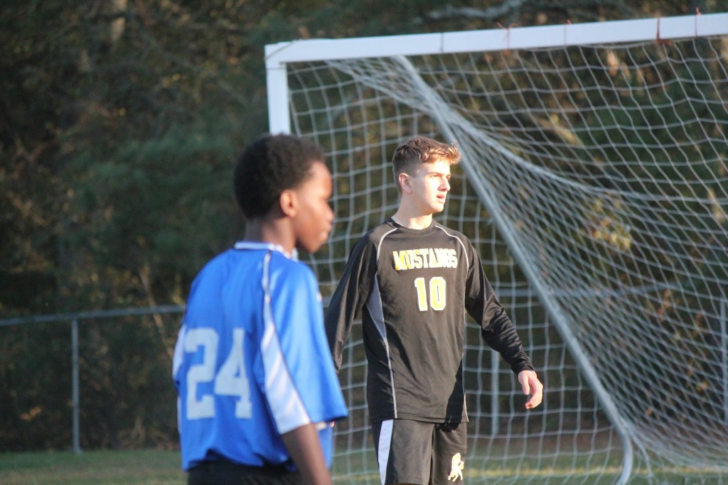 Young boys playing soccer on field.