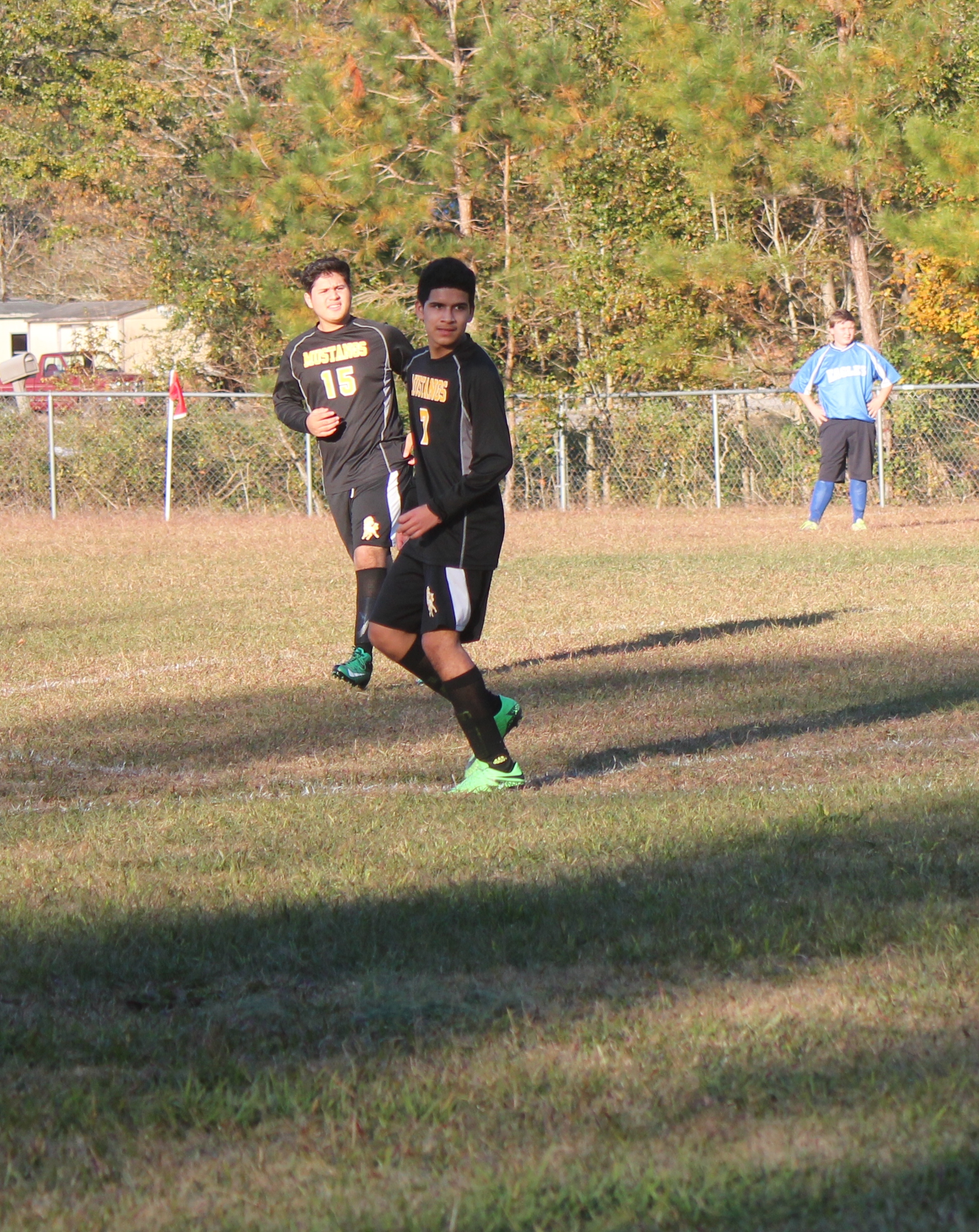 Young boy playing soccer on field.