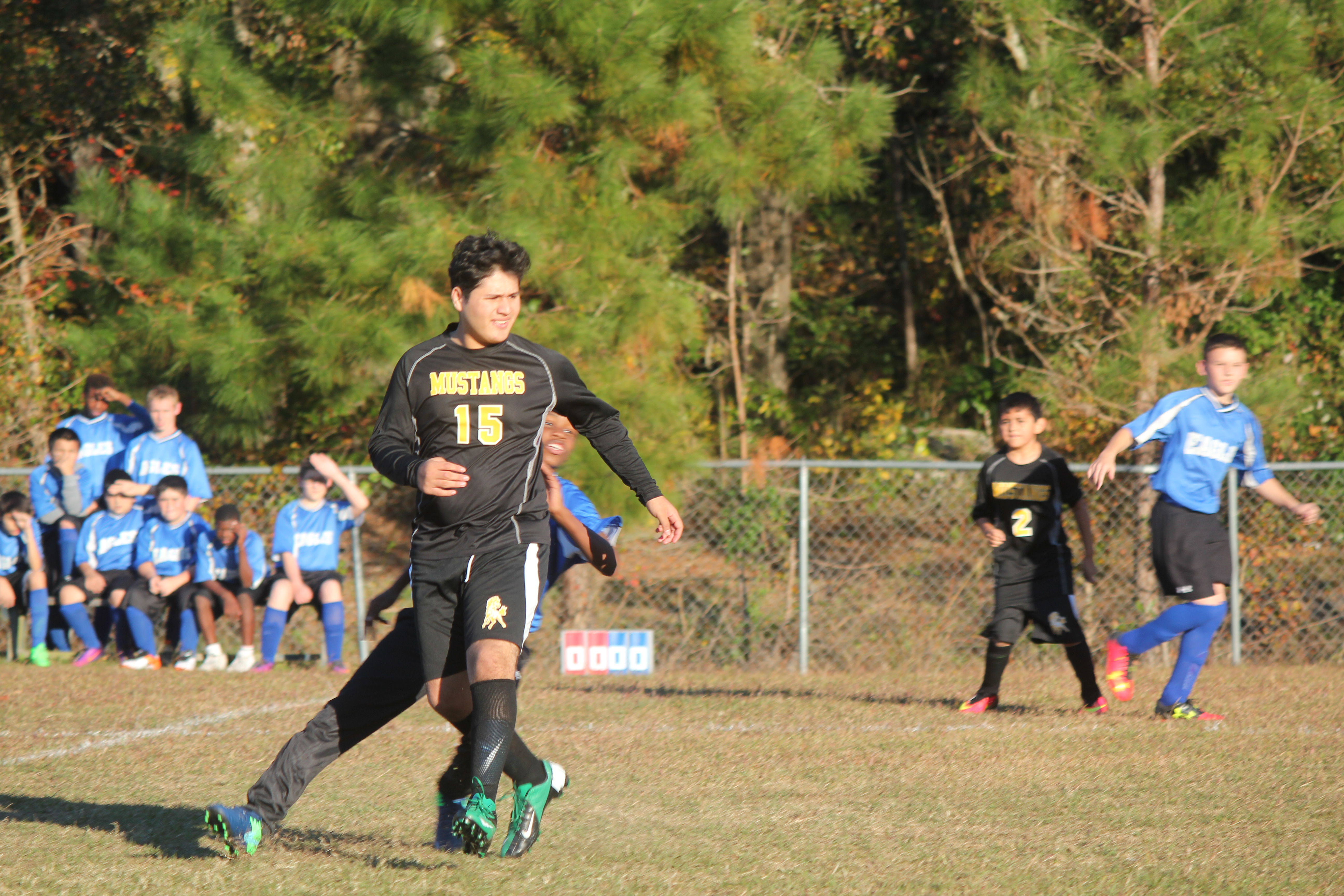 Young boy playing soccer on field.