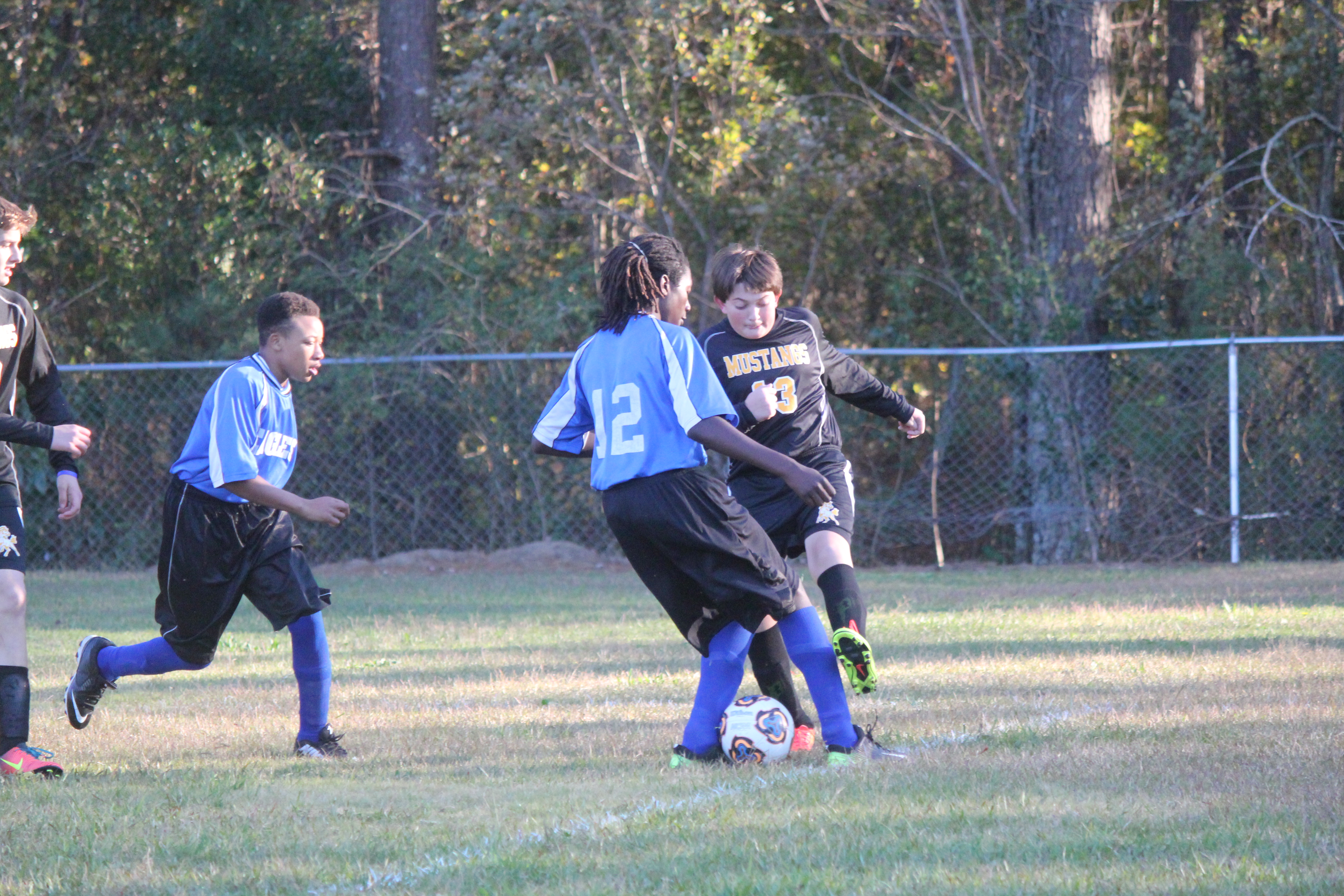 Young boys playing soccer on field.