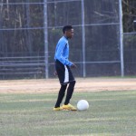 Young boy playing soccer on field.