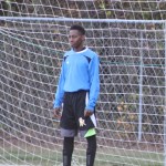 Young boy playing soccer on field.