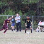 young boys playing soccer on a field.