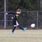 A young boy playing soccer on a field.