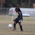 A young boy playing soccer on a field.